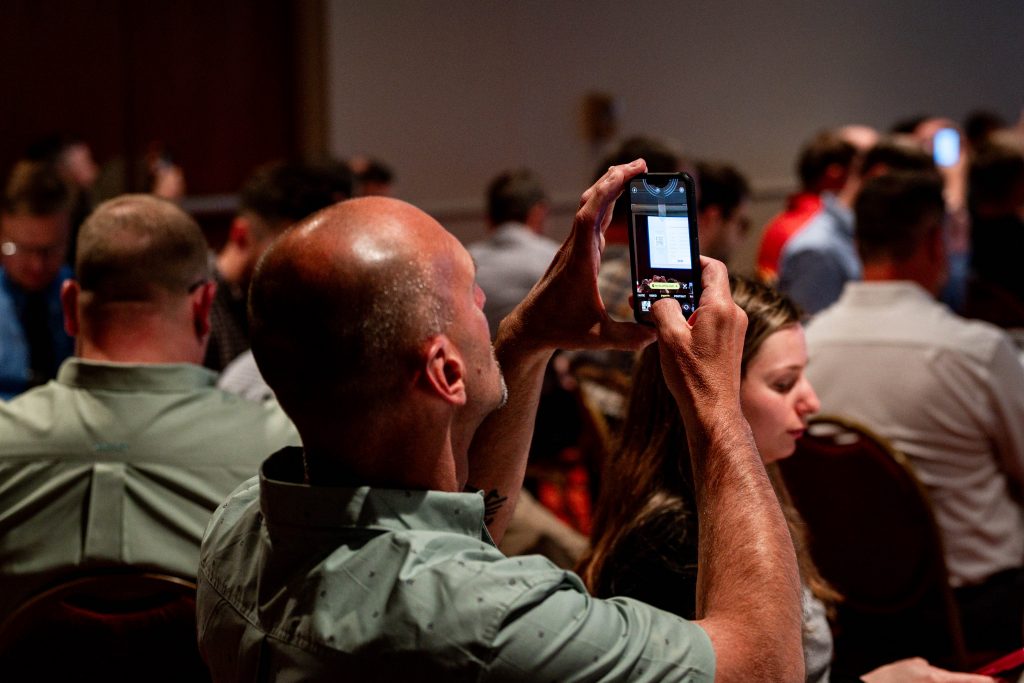 Man using phone to scan QR code for live survey